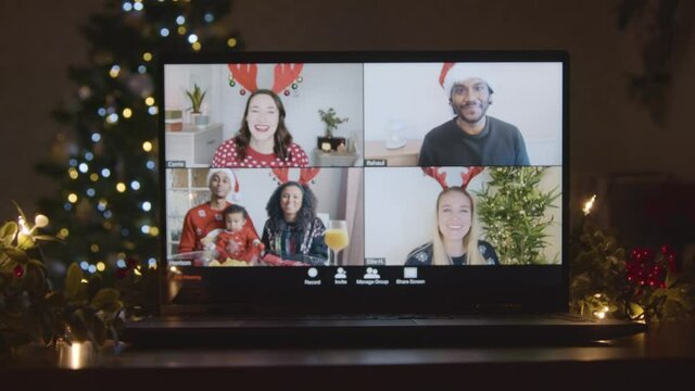Sliding Shot Approaching Laptop Screen with 4 Way Split Screen of Friends In Christmas Video Call