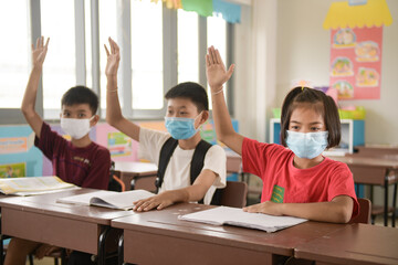 school kids with protection face mask against flu virus at lesson in classroom