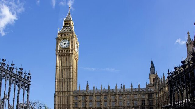 Time lapse of big ben tower or clock during a sunny cloudy day. There is the tower in close up and the clouds in background