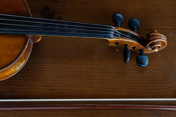 Part of a violin on a brown background. Violin handle