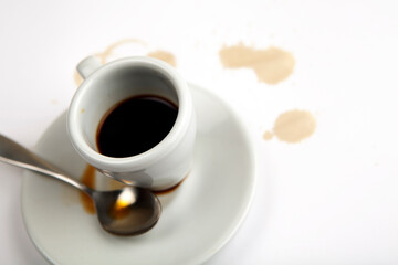 Espresso cup with silver spoon. Coffee stains on the side. Selective focus on object.