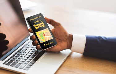 Black businessman holding smartphone with taxi app interface