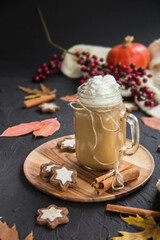 Pumpkin spiced latte or coffee in a cup on a turquoise vintage background. Autumn, fall, or winter hot drink. Cozy breakfast or snack.