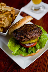 Hamburger. Grade A grass fed angus beef, ground into hamburger meat. Hamburger patties seasoned w/ salt & pepper & flame grilled topped w/ cheddar cheese. O toasted bun w/ lettuce tomato onion Cheese