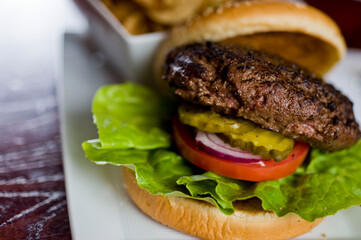 Hamburger. Grade A grass fed angus beef, ground into hamburger meat. Hamburger patties seasoned w/ salt & pepper & flame grilled topped w/ cheddar cheese. O toasted bun w/ lettuce tomato onion Cheese