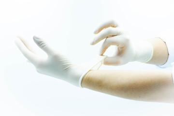 Doctor hands putting on sterile gloves for tests or operations, white background