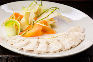 chicken fillet with vegetables on a white plate