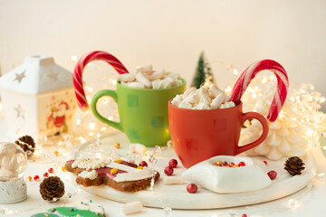 Christmas hot chocolate with marshmallow and gingerbread cookies on white wooden table. Traditional hot drink at Christmas.