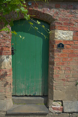 an arched green door made of wood 