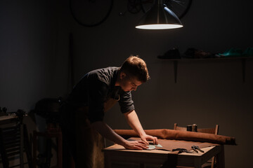 a hereditary shoemaker makes shoes from leather in the family workshop