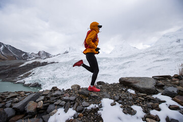 Woman trail runner cross country running on high altitude mountain ridge