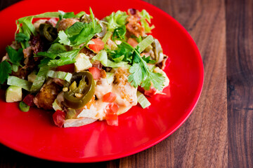 Nachos. Tex-Mex or Mexican restaurant classic traditional menu item. Homemade crispy tortilla chips topped w/ melted cheddar cheese, pico de gallo, black beans, jalapenos, spicy guacamole sour cream