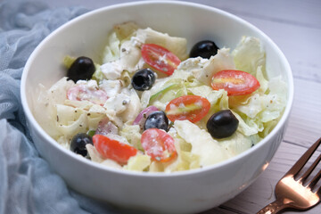 Close up of greek salad in a bowl on table.