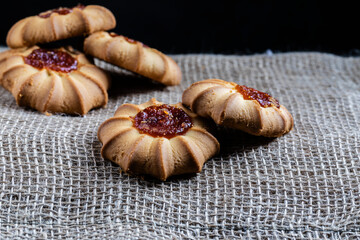 Kurabye cookies with filling on a wooden plate.