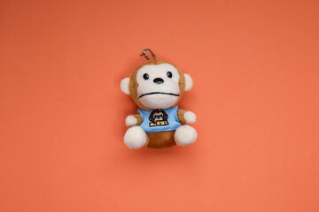 A soft toy monkey isolated on orange background 