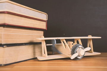 Airplane model on old educational book in library for history education and commemoration for Wright Brothers day, International civil aviation day