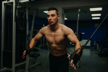 Fototapeta na wymiar One man exercising suspension training trx in dark gym