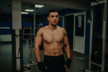 Fototapeta na wymiar Fitness shaped muscle man posing on gym. Caucasian, instructor.