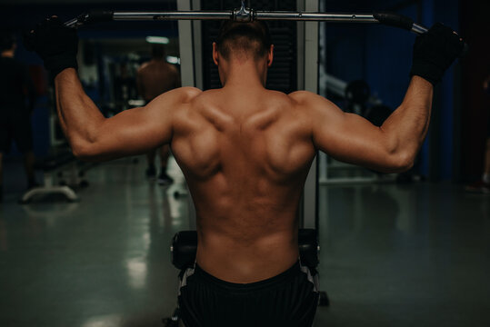 Man with nude torso, and muscular back in gym enjoy training.Sport and gym concept. Sportsman, athlete, muscular.