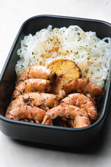 Asian food: rice noodles with prawns and herbs in a bowl. Soy sauce with garlic, ginger and lemon.