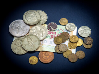 The old soviet coins and banknote are on the dark background.