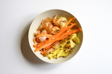 food waste from domestic kitchen, cleaning from vegetables onions potatoes and carrots in a plate...