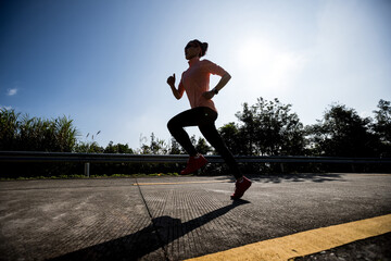 Female runner running on mountain top on winter day