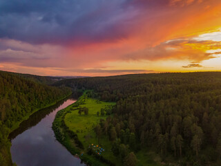 Fototapeta premium Sunset over a rocky river. Aerial view, kayak camp in a pine forest. River Ai, South Ural Mountains, Russia.