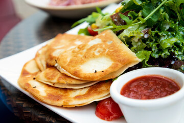 Delicious Mexican quesallidas made with chicken, tomato pieces and served with guacamole sauce.