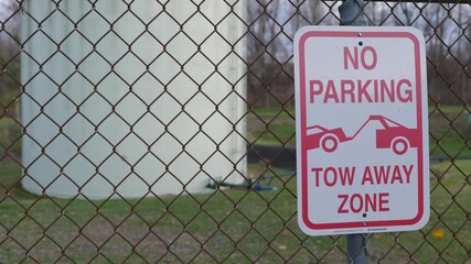 No parking tow away sign on chainlink fence