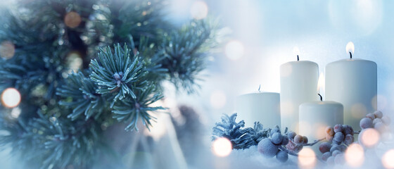 Candles with fir branches in the winter sunlight. Frozen christmas decoration with festive bokeh....
