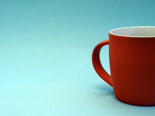 Simple orange cup without label on blue background