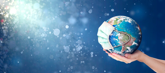 Hands Holding earth global In Abstract christmas lights background . Elements of this image furnished by NASA