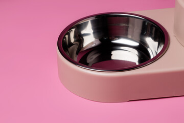 Empty pet bowl on pink background close up