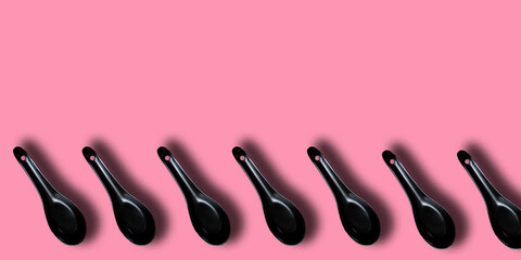 cuchara de cocina negra con fondo rosa y espacio para texto