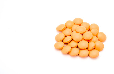 closeup of orange pills on white background