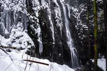 English

Waterfall in winter with huge icicles and snow. Beautiful landscape and cliff. Long exposure at the Burgbach waterfall in the Black Forest in winter