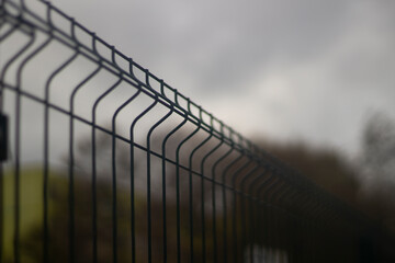 Metal fence. Steel mesh for protection against thieves. Checkered structure of metal rods. An ordinary fence.