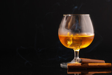 Glass of whisky and lighted cigar on black background