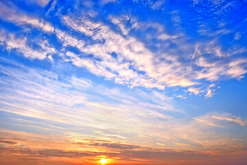 cold sunset sky on winter evening landscape background. Wide panorama cloudscape. Scenic sky with setting sun behind clouds. Nature abstract wallpaper