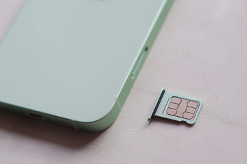 SIM card slot laying next to the green phone