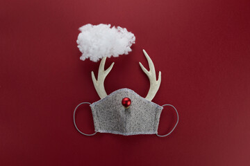 Reindeer horns with face mask and red ball and cloud. Pandemic Christmas concept. Flat lay.