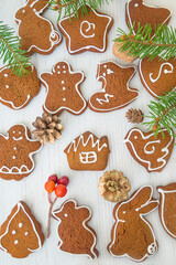 Various gingerbread cookies on white wooden background. Vertical pictrure. Christmas holiday greeting card