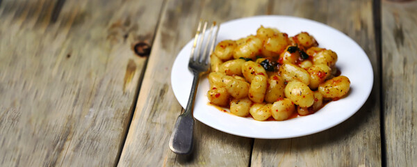 Gnocchi in chili tomato sauce on a white plate.