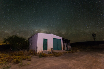 Wide Angle view of an old shed/barn on a farm in the Tankwa karoo at night with the milky way in...