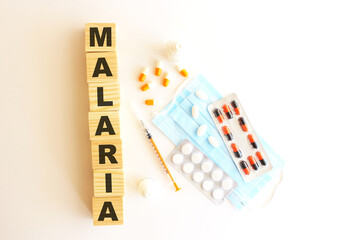 The word MALARIA is made of wooden cubes on a white background. Medical concept.