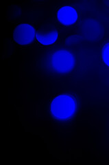 Abstract pattern of blue bokeh lights on black background