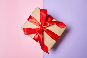 Christmas or New Year gift box with red ribbon on a colorful background