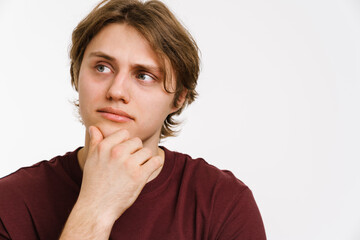 Pensive young man thinking isolated over background