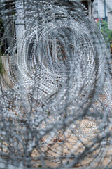 Close-up of sharp razor wire. The coiled metal with sharp edges creates a dangerous and restrictive...